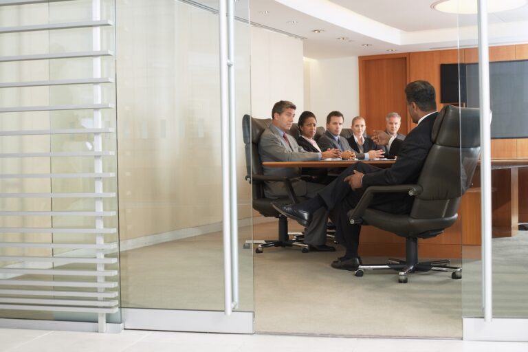 A group of business professionals sitting around a conference table during a meeting.